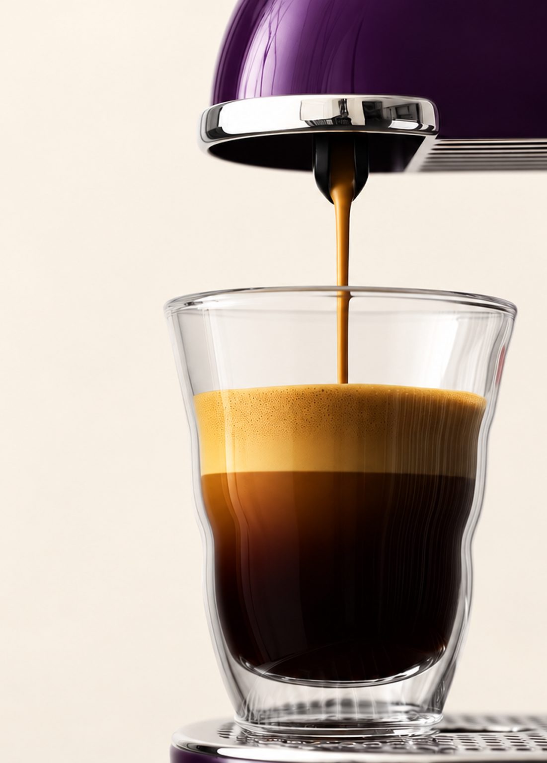 Un espresso et sa mousse dans un verre double paroi, sous une machine à capsules violette